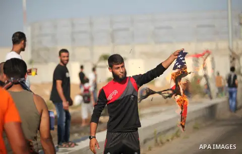 A Palestinian protester burns U.S flag during clashes with Israeli security forces at the Erez crossing checkpoint in the northern Gaza Strip October 16, 2015. The unrest that has engulfed Jerusalem and the occupied West...