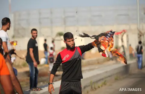 A Palestinian protester burns U.S flag during clashes with Israeli security forces at the Erez crossing checkpoint in the northern Gaza Strip October 16, 2015. The unrest that has engulfed Jerusalem and the occupied West...