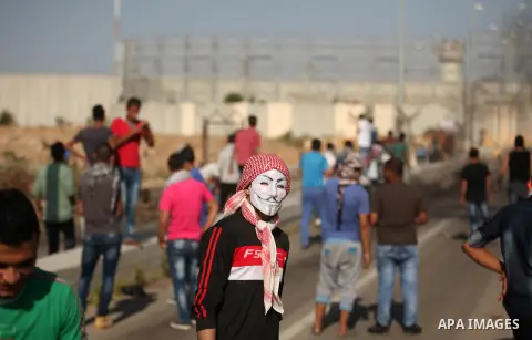 A masked Palestinian proterster looks on during clashes with Israeli security forces at the Erez crossing checkpoint in the northern Gaza Strip October 16, 2015. The unrest that has engulfed Jerusalem and the occupied We...
