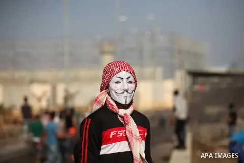 A masked Palestinian proterster looks on during clashes with Israeli security forces at the Erez crossing checkpoint in the northern Gaza Strip October 16, 2015. The unrest that has engulfed Jerusalem and the occupied We...