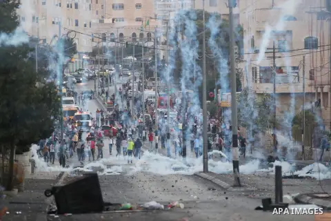 Palestinian protesters run for cover from tear gas during clashes with Israeli security forces at the main entrance of the West Bank city of Bethlehem on October 16, 2015. The unrest that has engulfed Jerusalem and the o...