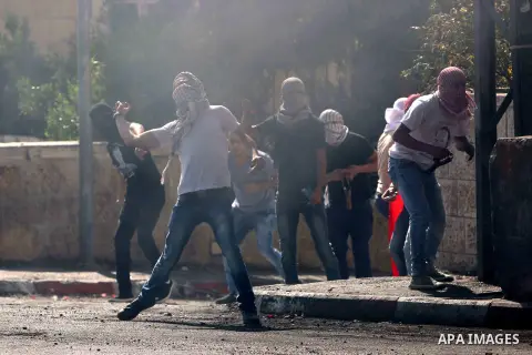 Palestinian protesters throw stones towards Israeli security forces during clashes at the main entrance of the West Bank city of Bethlehem on October 16, 2015. The unrest that has engulfed Jerusalem and the occupied West...