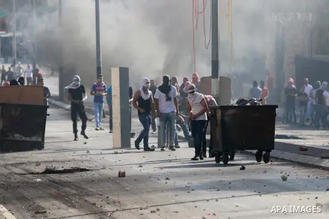 Palestinian protesters throw stones towards Israeli security forces during clashes at the main entrance of the West Bank city of Bethlehem on October 16, 2015. The unrest that has engulfed Jerusalem and the occupied West...