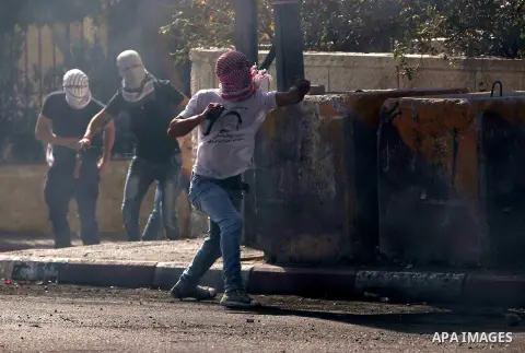 Palestinian protesters throw stones towards Israeli security forces during clashes at the main entrance of the West Bank city of Bethlehem on October 16, 2015. The unrest that has engulfed Jerusalem and the occupied West...