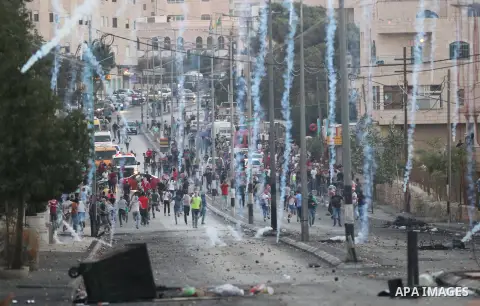 Palestinian protesters run for cover from tear gas during clashes with Israeli security forces at the main entrance of the West Bank city of Bethlehem on October 16, 2015. The unrest that has engulfed Jerusalem and the o...