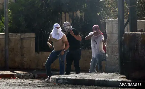 Palestinian protesters throw stones towards Israeli security forces during clashes at the main entrance of the West Bank city of Bethlehem on October 16, 2015. The unrest that has engulfed Jerusalem and the occupied West...