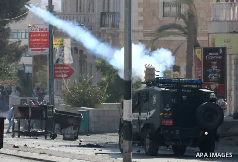 An Israeli military vehicle fires tear gas towards Palestinian protesters during clashes at the main entrance of the West Bank city of Bethlehem on October 16, 2015. The unrest that has engulfed Jerusalem and the occupie...