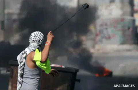 A Palestinian protester hurls stones towards Israeli security forces during clashes at the main entrance of the West Bank city of Bethlehem on October 16, 2015. The unrest that has engulfed Jerusalem and the occupied Wes...
