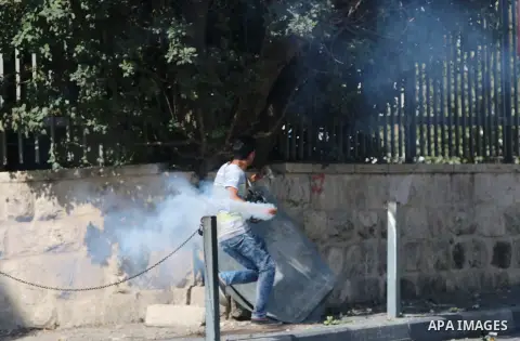 A Palestinian protester throws back a tear gas canister during clashes with Israeli security forces at the main entrance of the West Bank city of Bethlehem on October 16, 2015. The unrest that has engulfed Jerusalem and...