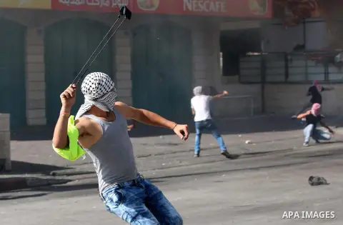A Palestinian protester hurls stones towards Israeli security forces during clashes at the main entrance of the West Bank city of Bethlehem on October 16, 2015. The unrest that has engulfed Jerusalem and the occupied Wes...