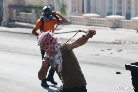 A Palestinian protester hurls stones towards Israeli security forces during clashes at the main entrance of the West Bank city of Bethlehem on October 16, 2015. The unrest that has engulfed Jerusalem and the occupied Wes...