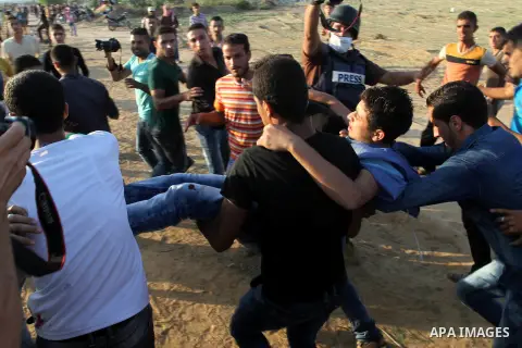 Palestinian protester carry an injured comrade during clashes with Israeli security forces near the border fence between Israel and the southern Gaza Strip October 16, 2015. The unrest that has engulfed Jerusalem and the...