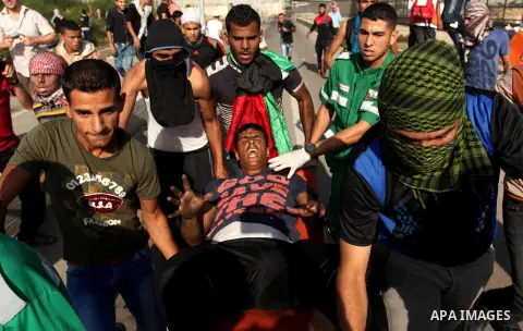Palestinian protester carry an injured comrade during clashes with Israeli security forces at the Erez crossing checkpoint in the northern Gaza Strip October 16, 2015. The unrest that has engulfed Jerusalem and the occup...