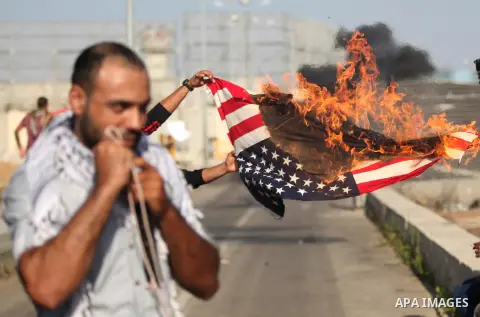 A Palestinian protester burns U.S flag during clashes with Israeli security forces at the Erez crossing checkpoint in the northern Gaza Strip October 16, 2015. The unrest that has engulfed Jerusalem and the occupied West...