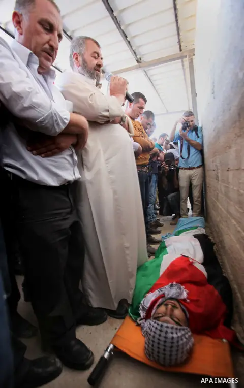 Mourners carry the body of Palestinian Ihab Hanani, 19, during his funeral at the Bet Forik village near the West Bank city of Nablus, on October 17, 2015. The unrest that has engulfed Jerusalem, Gaza and the occupied We...
