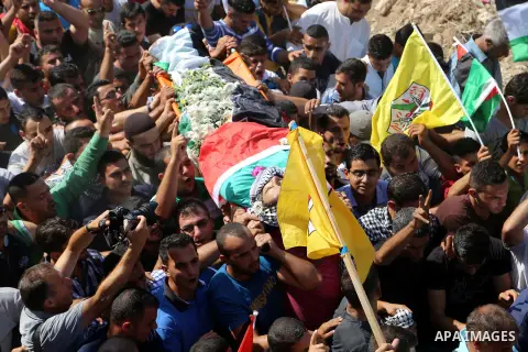 Relatives carry the body of Palestinian Eyad Awawda, who while disguised as a news photographer, stabbed and wounded a soldier at an entrance to the West Bank settlement of Kiryat Arba before being shot dead, during his...
