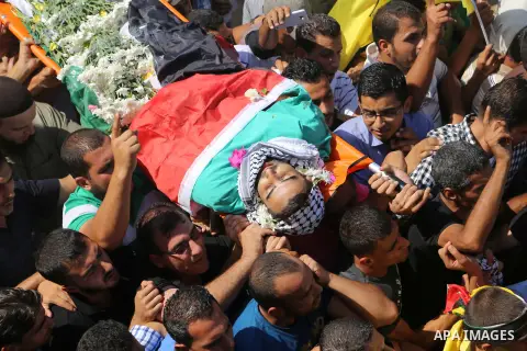 Relatives carry the body of Palestinian Eyad Awawda, who while disguised as a news photographer, stabbed and wounded a soldier at an entrance to the West Bank settlement of Kiryat Arba before being shot dead, during his...