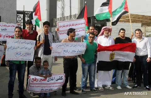 Palestinians hold banners during a protest demanding the Egyptian authorities for the opening of the Rafah crossing in Gaza city, on Oct. 18, 2015. Photo by Abed Rahim Khatib