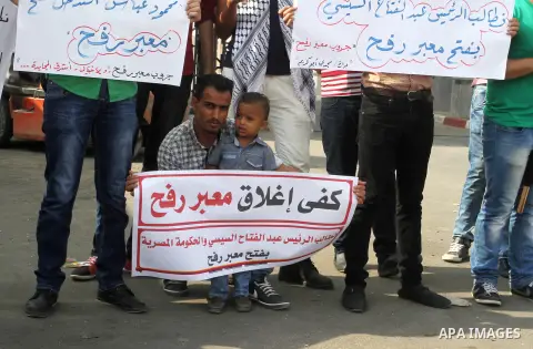 Palestinians hold banners during a protest demanding the Egyptian authorities for the opening of the Rafah crossing in Gaza city, on Oct. 18, 2015. Photo by Abed Rahim Khatib