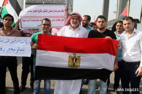 Palestinians hold banners during a protest demanding the Egyptian authorities for the opening of the Rafah crossing in Gaza city, on Oct. 18, 2015. Photo by Abed Rahim Khatib