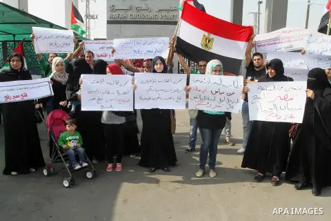 Palestinians hold banners during a protest demanding the Egyptian authorities for the opening of the Rafah crossing in Gaza city, on Oct. 18, 2015. Photo by Abed Rahim Khatib