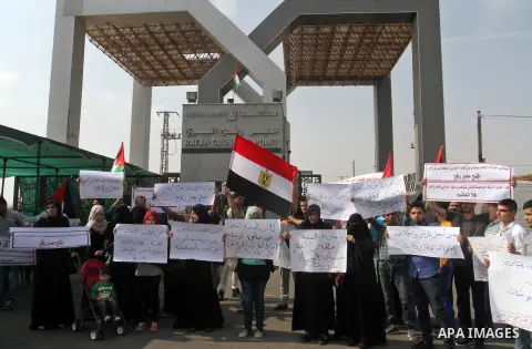 Palestinians hold banners during a protest demanding the Egyptian authorities for the opening of the Rafah crossing in Gaza city, on Oct. 18, 2015. Photo by Abed Rahim Khatib