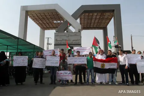 Palestinians hold banners during a protest demanding the Egyptian authorities for the opening of the Rafah crossing in Gaza city, on Oct. 18, 2015. Photo by Abed Rahim Khatib