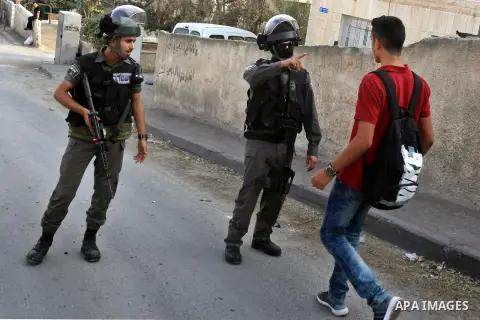 Israeli border guard block a Palestinian school boy from entering a road at a newly erected checkpoint in Jerusalem's neighborhood of Jabal al-Mokaber on October 19, 2015. Israeli police began erecting a wall in east Jer...