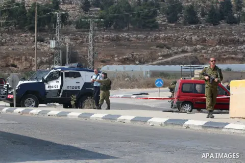Israeli soldiers inspect the scene where a settler was ran over by a Palestinian truck driver in an incident that followed stone-throwing near Al Fawar Refugee camp near Hebron city, 20 October 2015. The Israeli settler...