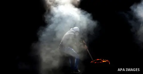 A Palestinian protester burns tires during clashes with Israeli security forces near the Jewish settlement of Beit El, near the West Bank city of Ramallah October 20, 2015. Triggered by Israeli incursions into the Al-Aqs...