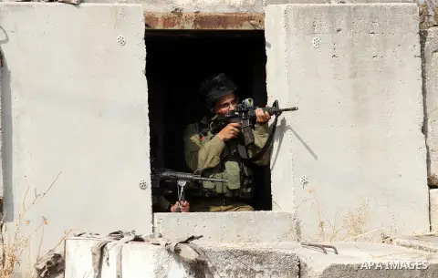 An Israeli soldier aims at Palestinian protesters during clashes in the West Bank town of Tulkarm, October 20, 2015. Triggered by Israeli incursions into the Al-Aqsa Mosque compound last month, violence and protests agai...