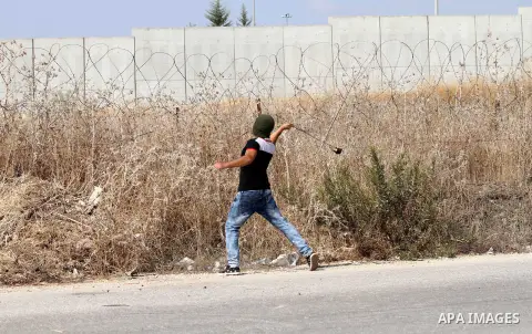 A Palestinian protester uses a sling shot to throw stones at Israeli security forces during clashes in the West Bank town of Tulkarm, October 20, 2015. Triggered by Israeli incursions into the Al-Aqsa Mosque compound las...
