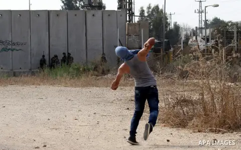 A Palestinian protester throws stones at Israeli security forces during clashes in the West Bank town of Tulkarm, October 20, 2015. Triggered by Israeli incursions into the Al-Aqsa Mosque compound last month, violence an...