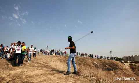 A Palestinian protester uses a sling shot to throw stones at Israeli security forces during clashes in the West Bank town of Tulkarm, October 20, 2015. Triggered by Israeli incursions into the Al-Aqsa Mosque compound las...