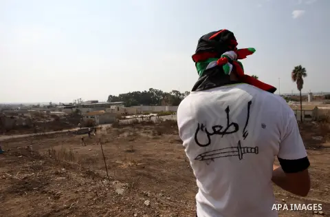 A masked Palestinian protester wears a T-shirt reading in Arabic "stab" during clashes with Israeli security forces in the West Bank town of Tulkarm, October 20, 2015. Triggered by Israeli incursions into the Al-Aqsa Mos...