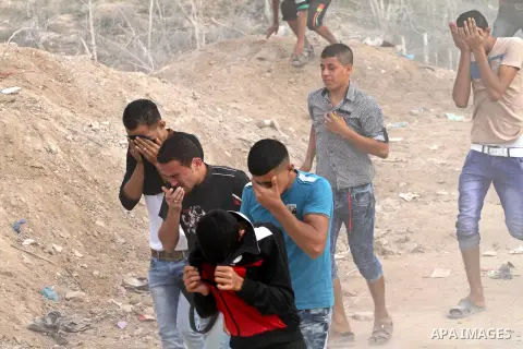 Palestinian protesters run for cover from tear gas during clashes with Israeli security forces near the border between Israeli and the eastern Gaza city, on October 23, 2015. Palestinian factions called for mass rallies...