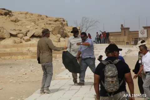 Actor Morgan Freeman, is surrounded by his film crew as he visits the Giza Pyramids, just outside Cairo, Egypt, Friday, Oct. 23, 2015. Freeman is in Egypt to work on a National Geographic documentary titled, "The Story o...