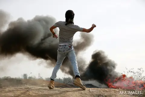 A Palestinian protester uses a sling shot to throw stones during clashes with Israeli security forces near the border between Israeli and central Gaza Strip, on October 23, 2015. Palestinian factions called for mass rall...