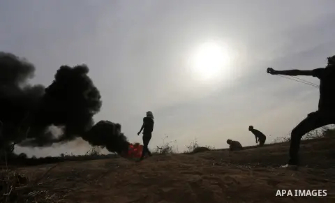A Palestinian protester uses a sling shot to throw stones during clashes with Israeli security forces near the border between Israeli and central Gaza Strip, on October 23, 2015. Palestinian factions called for mass rall...