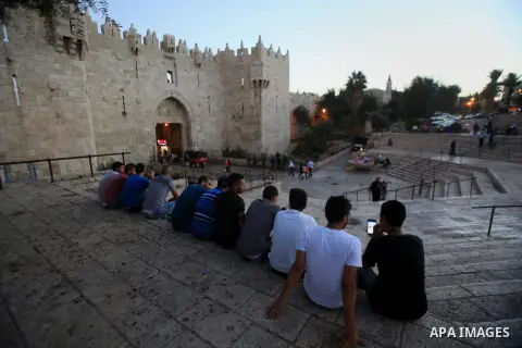 Palestinian youths sit at Damascus Gate of the Jerusalem's Old City in Jerusalem's, Oct. 24, 2015. Kerry said Saturday that Israel and Jordan have agreed on steps aimed at reducing tensions at a holy site in Jerusalem th...