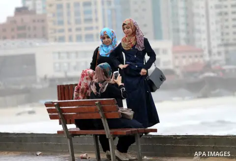 Palestinian girls set in front of the beach of Gaza city during a winter storm on October 25, 2015. Photo by Mohammed Asad