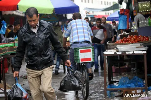 Palestinians shop at a market during a winter storm in Gaza city on October 25, 2015. Photo by Mohammed Asad