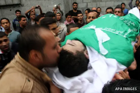 Palestinian men carry the body of Khalil Obied, who died of wounds suffered during clashes with Israeli forces, during his funeral in Khan Yunis, in the southern Gaza Strip, on October 25, 2015. More than 80 people were...
