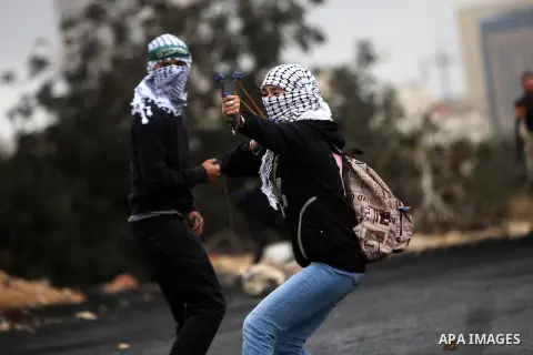 A female Palestinian protester uses a sling shot to throw stones towards Israeli security forces during clashes near the Jewish settlement of Beit El, near the West Bank city of Ramallah October 27, 2015. The current rou...