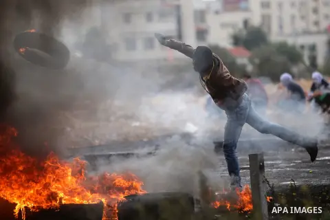 A Palestinian protesters burns tires during clashes with Israeli security forces near the Jewish settlement of Beit El, near the West Bank city of Ramallah October 27, 2015. The current round of violence began last month...