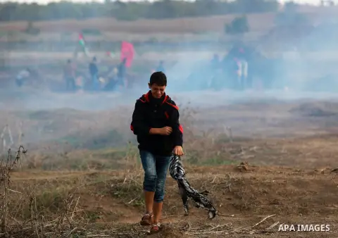A Palestinian protester runs for cover during clashes with Israeli troops near the border between Israel and Central Gaza Strip October 27, 2015. The current round of violence began last month with clashes at Jerusalem's...