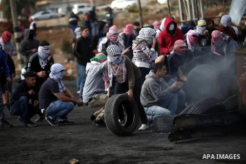 Palestinian protesters take cover during clashes with Israeli troops near the Jewish settlement of Bet El, near the West Bank city of Ramallah, October 29, 2015. Israeli security forces shot dead two Palestinian assailan...