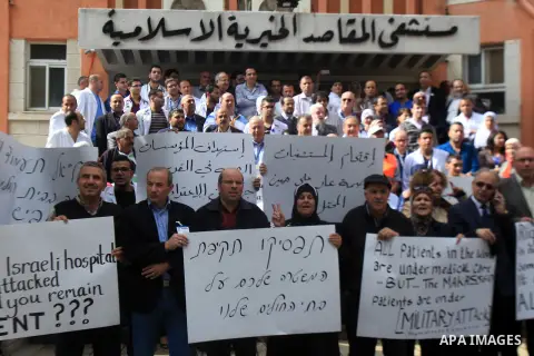 Palestinian doctors and medical employees take part in a protest outside the al-Makassed Hospital against the storming of the hospital by Israeli police, in east Jerusalem on October 29, 2015. Palestinian Minister of hea...