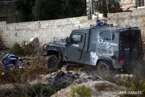 A Palestinian protester throws stones at an Israeli military vehicle during clashes near the Jewish settlement of Bet El, near the West Bank city of Ramallah, October 30, 2015. Since the start of October, violence that h...