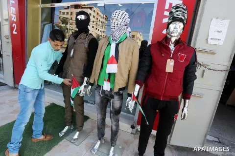 A Palestinian man display manikin wearing national clothes to show solidarity with the al-Aqsa mosque compound ana palestinians in the West Bank, at his shop, in Gaza city, on Nov. 01, 2015. Photo by Mohammed Asad